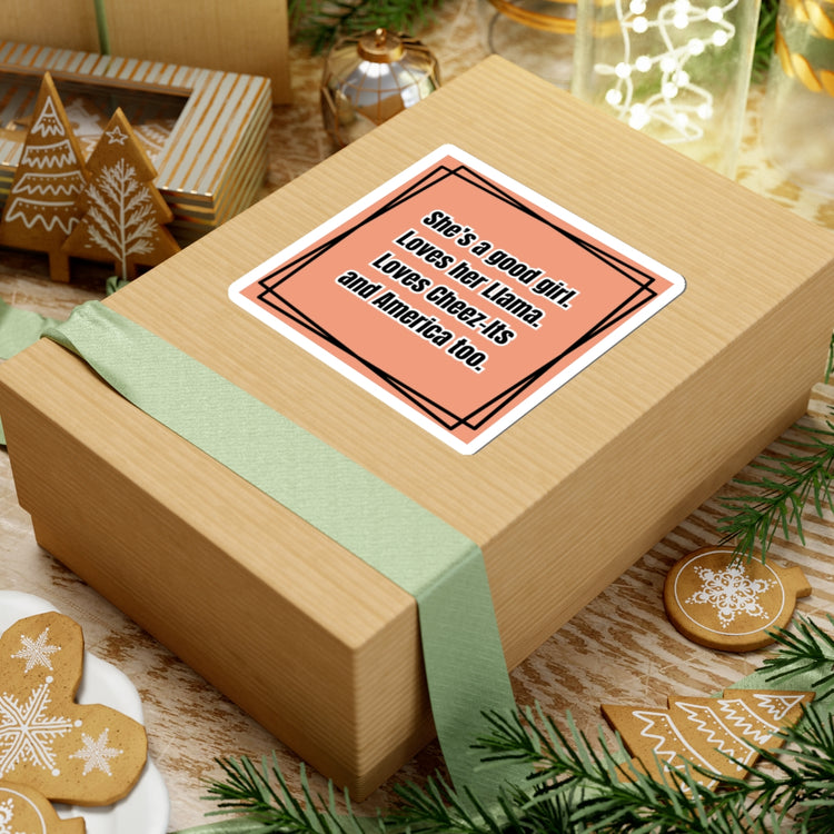 Gift box with a card on top, surrounded by Christmas decorations