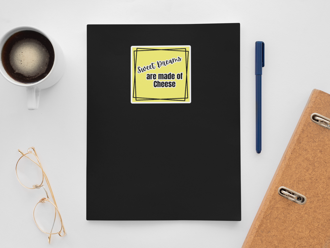 Black notebook with a yellow sticker, coffee cup, glasses, pen, and phone on a white surface