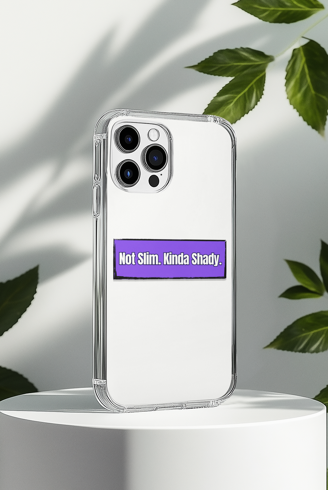Phone case with a humorous text "Not Slim, Kinda Shady" sticker on a white background with leaves.