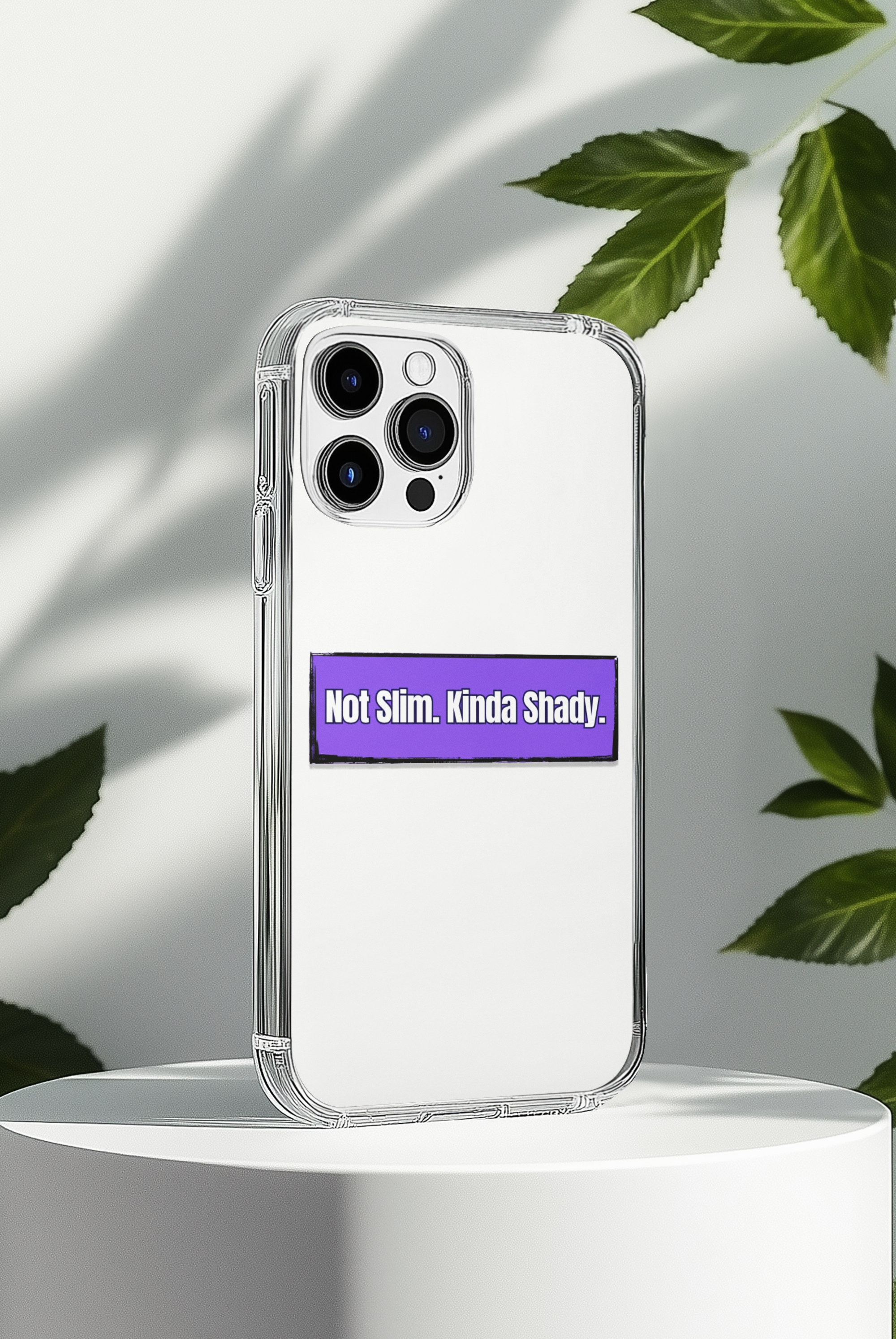 Phone case with a humorous text "Not Slim, Kinda Shady" sticker on a white background with leaves.