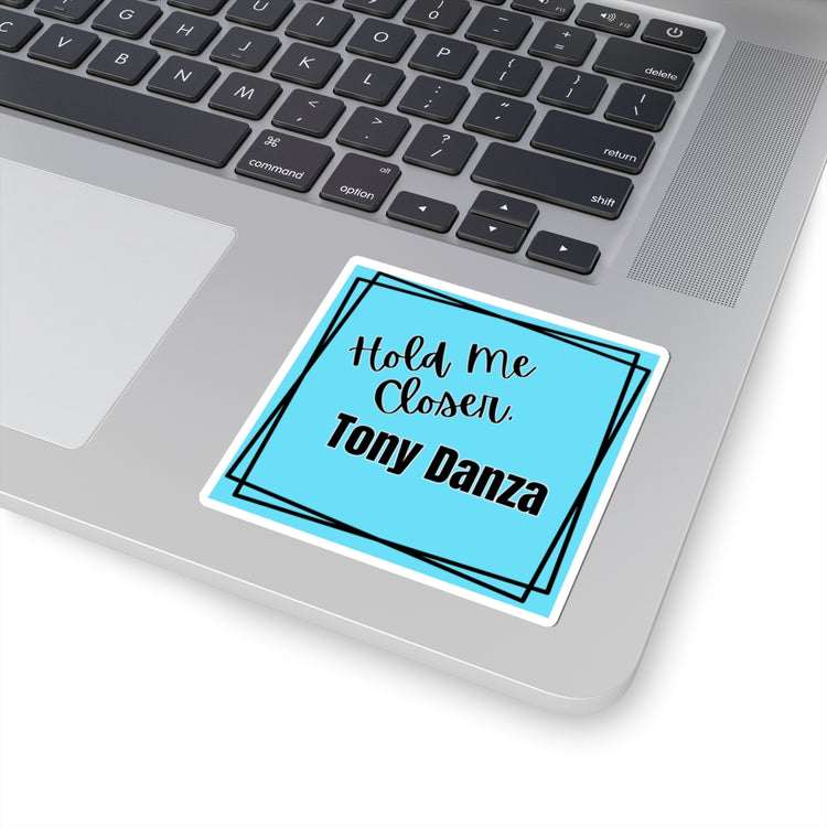 Laptop with a sticker that says 'Hold Me Closer. Tony Danza' on the palm rest area.
