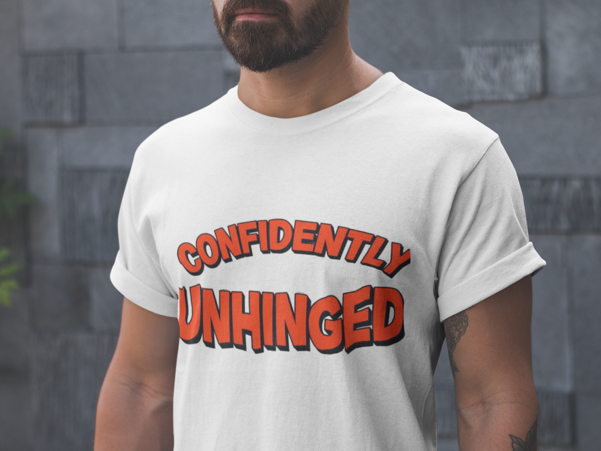 Man wearing a white t-shirt with 'CONFIDENTLY UNHINGED' text in red and black.