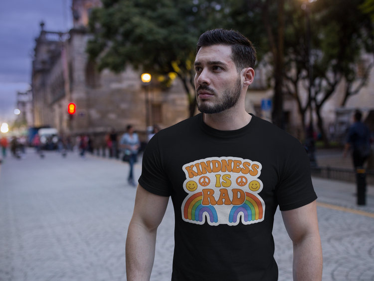 Man wearing a black t-shirt with 'Kindness is Rad' design in an urban setting