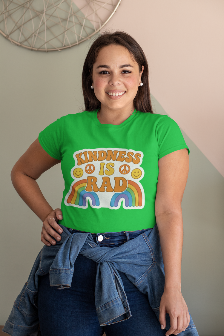 Person wearing a green t-shirt with 'Kindness is Rad' text and rainbow design.