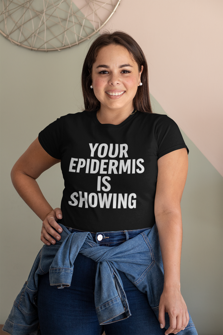 Woman wearing a black t-shirt with 'Your Epidermis is Showing' text, standing against a neutral wall.