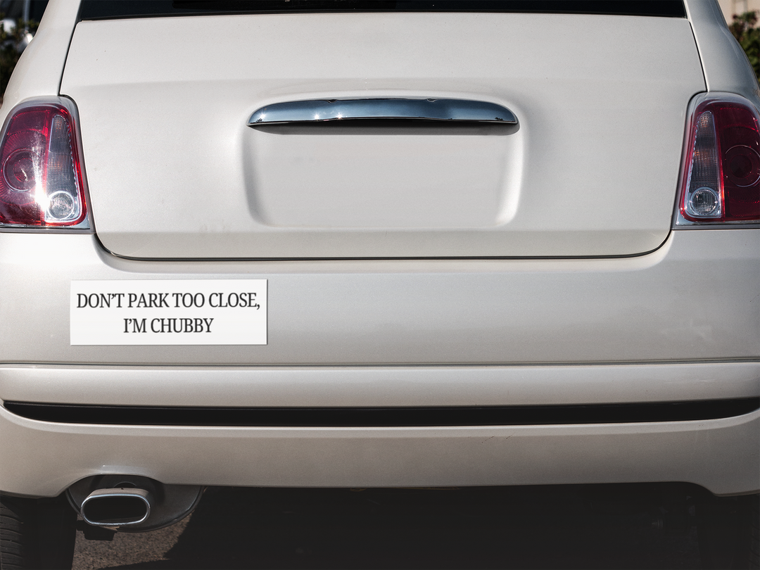 Car bumper with a humorous bumper sticker on a white car.