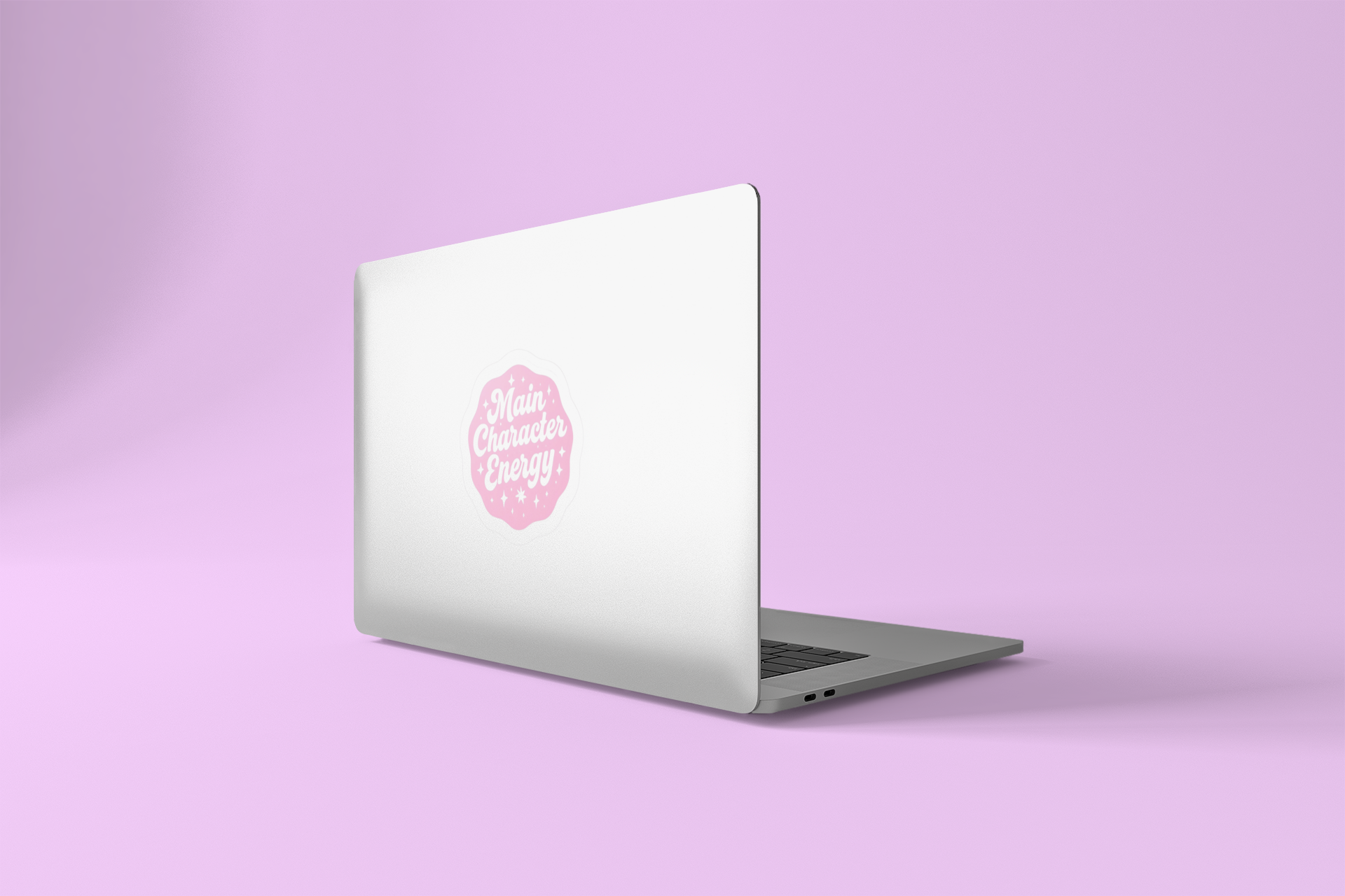 Silver laptop with a pink Main Character Energy sticker on a light purple background