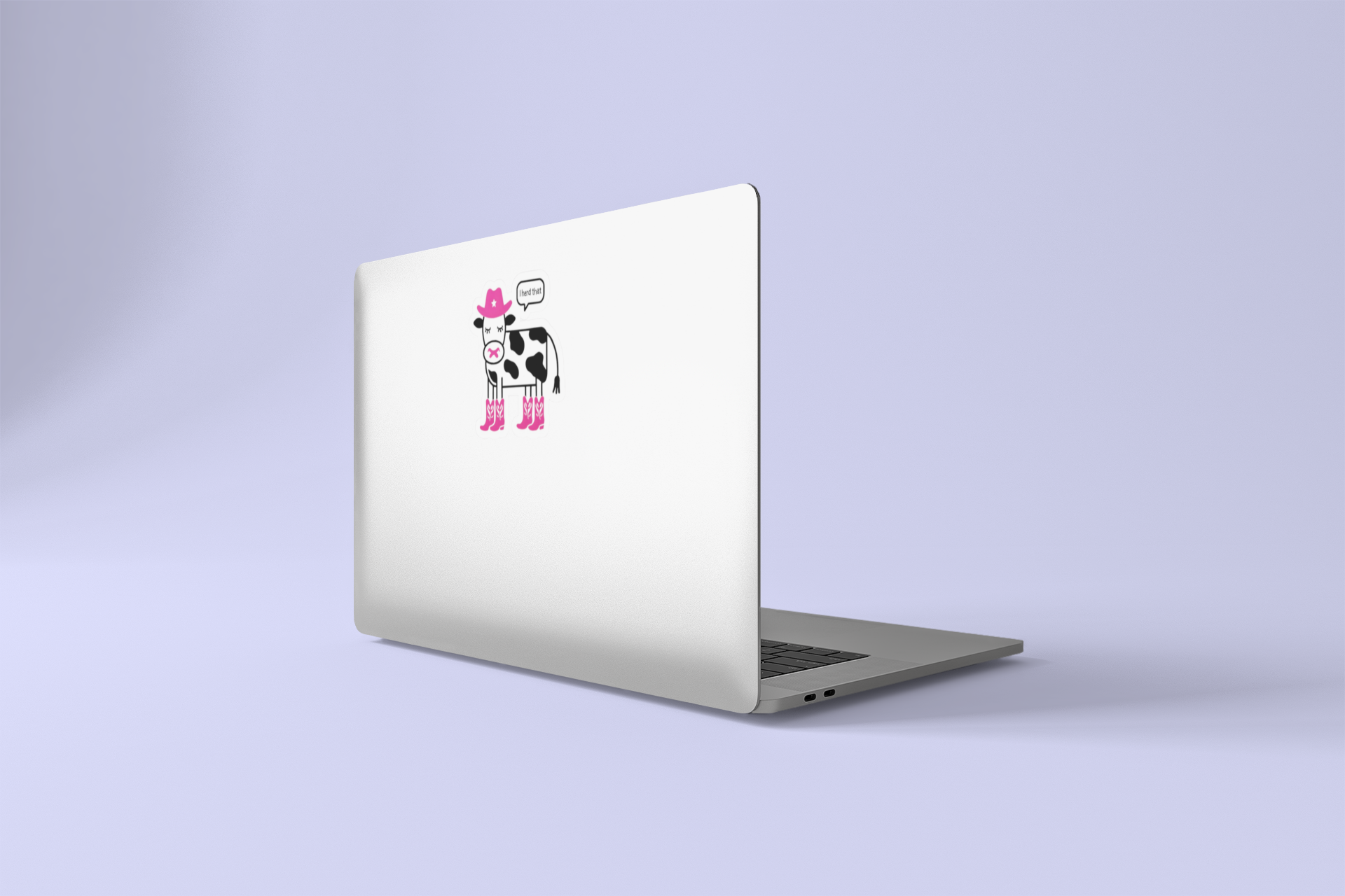 Laptop with a cow sticker on a light purple background