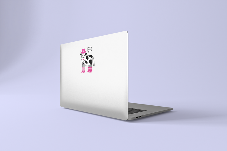 Laptop with a cow sticker on a light purple background