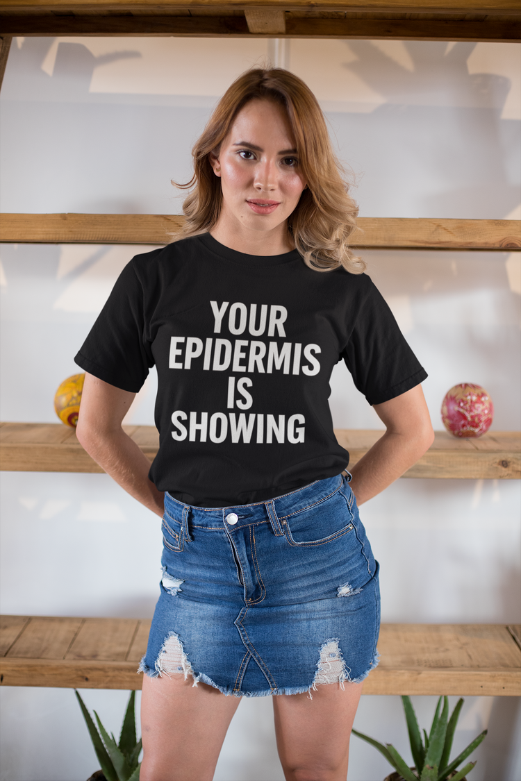 Woman wearing a black t-shirt with 'Your Epidermis is Showing' text, standing indoors.